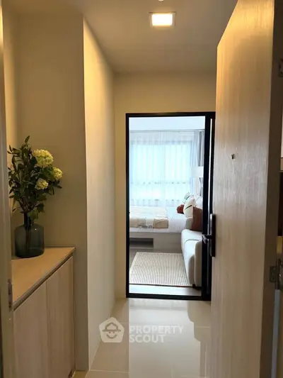 Modern apartment entrance leading to a cozy living room with natural light and stylish decor.