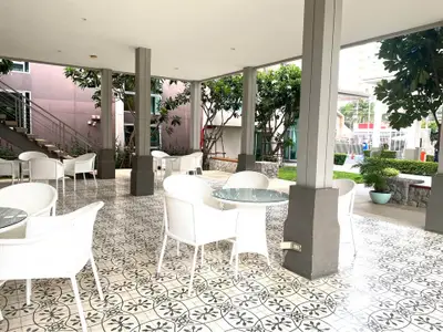 Charming outdoor seating area with stylish tile flooring and modern furniture in a serene garden setting.