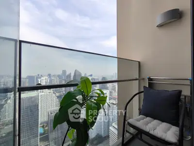 Stunning city view from a modern high-rise balcony with comfortable seating.