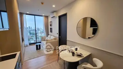 Modern living room with city view, cozy seating, and dining area in a stylish apartment.