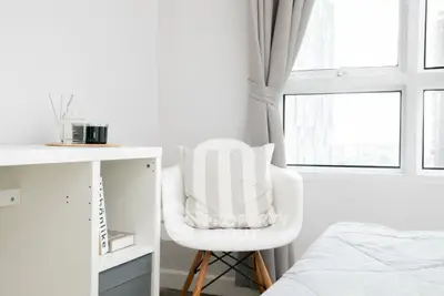 Bright and modern bedroom with stylish decor and large window view.