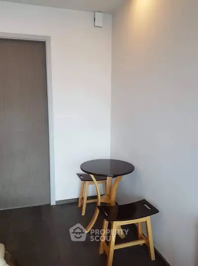 Cozy corner with modern wooden table and stools in minimalist interior design.