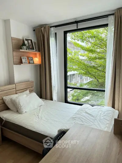 Cozy bedroom with large window and natural light in modern apartment
