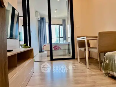 Modern apartment interior with open layout, featuring a cozy living area and a glimpse of the bedroom.