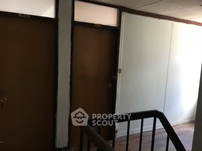 Interior hallway with wooden doors and railing in residential building