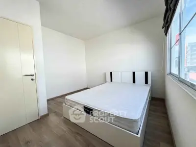 Spacious minimalist bedroom with large window and modern bed frame, perfect for natural light lovers.