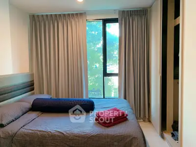 Cozy bedroom with large window and modern decor, perfect for relaxation and comfort.