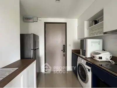 Modern kitchen with sleek appliances and washing machine, perfect for urban living.