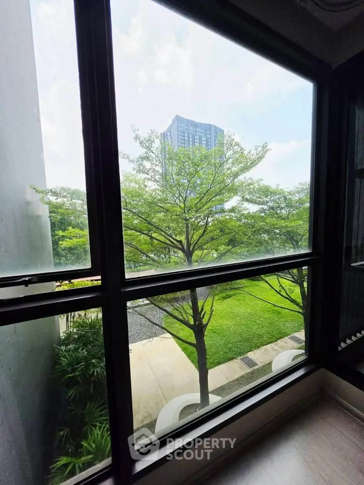 Stunning view from window overlooking lush greenery and modern building, perfect for nature lovers.