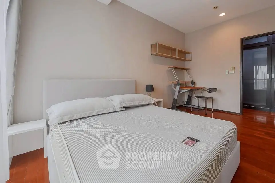 Spacious bedroom with modern furniture and wooden flooring, ideal for comfort and relaxation.