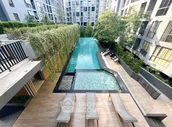 Luxurious condominium pool area with modern design and lush greenery, perfect for relaxation and leisure.