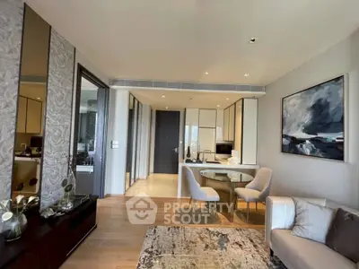 Modern open-plan living room with stylish decor and kitchen area in luxury apartment.