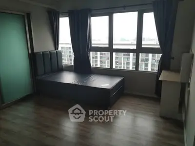 Spacious bedroom with large windows and city view