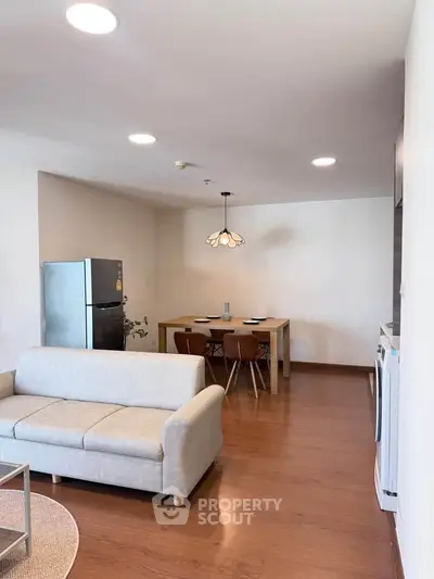 Modern living room with dining area and sleek furniture in a cozy apartment setting.
