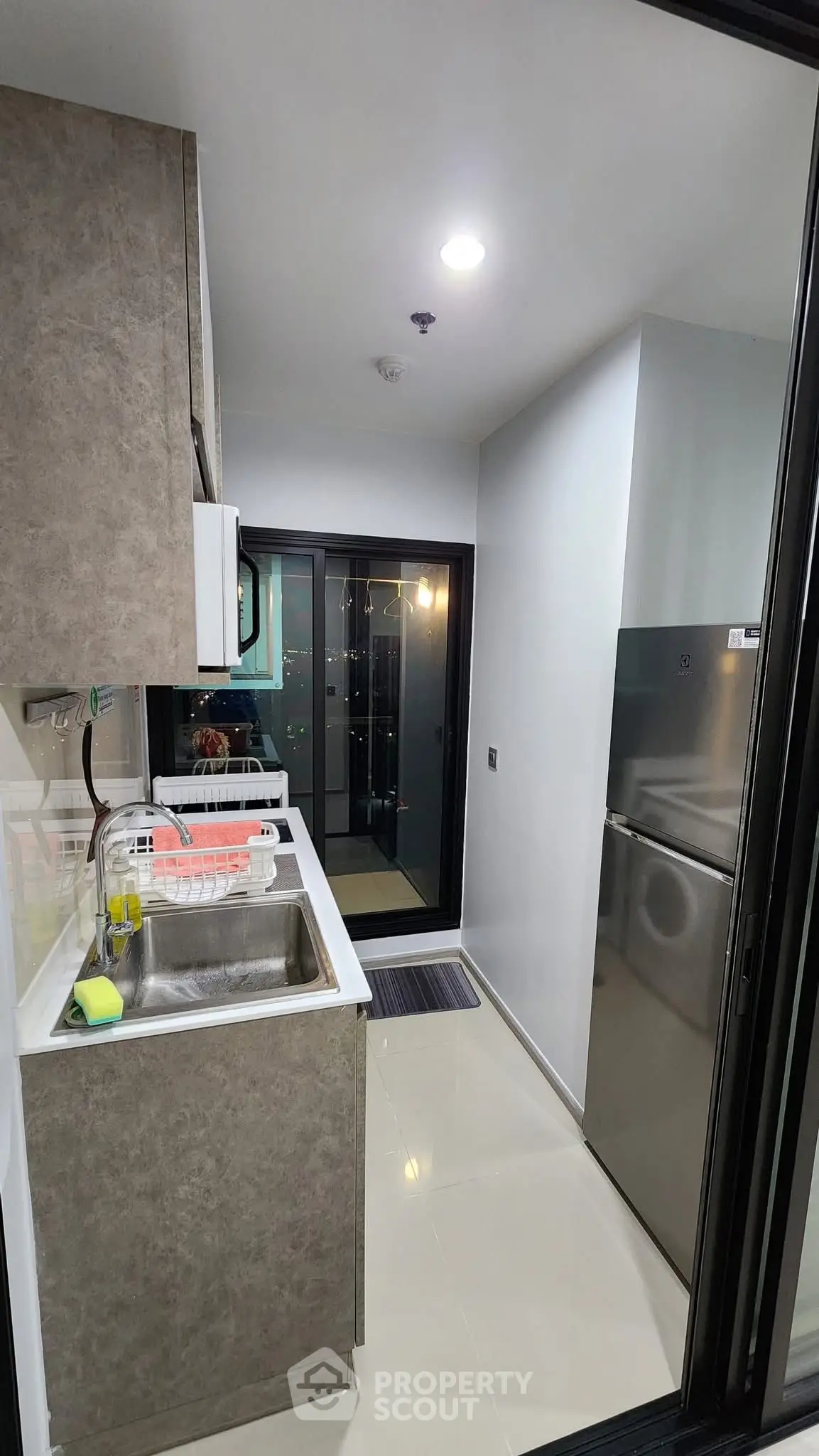 Modern compact kitchen with sleek appliances and balcony view