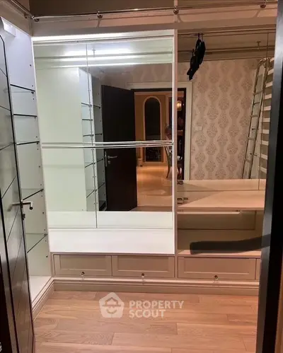 Luxurious walk-in closet with elegant shelving and hardwood floors