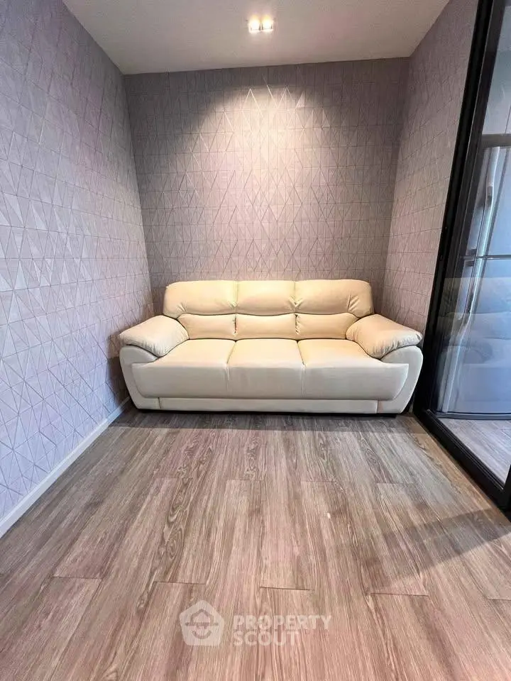 Modern living room with stylish sofa and geometric wallpaper, perfect for cozy relaxation.