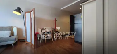 Modern living room with stylish furniture and wooden flooring, featuring a cozy dining area and contemporary decor.