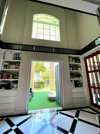 Stunning high-ceiling interior with elegant flooring and garden view
