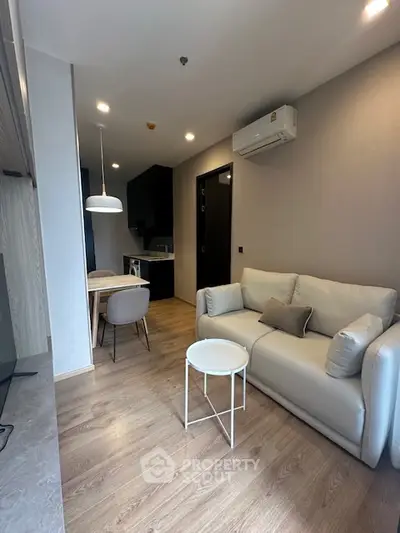 Modern living room with cozy sofa and stylish dining area in open layout.
