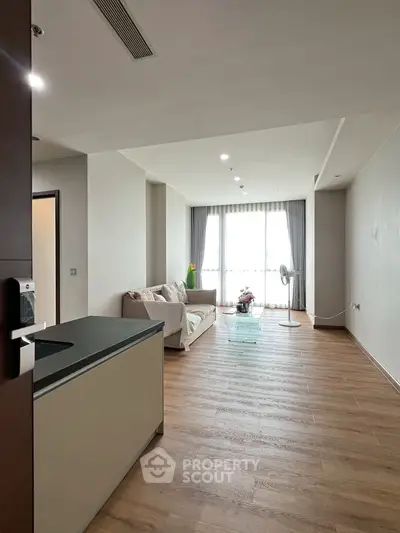 Spacious modern living room with wooden flooring and natural light