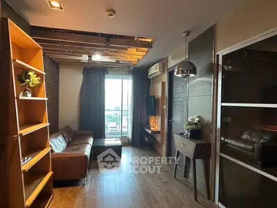 Modern living room with stylish decor and large window offering natural light and city view.