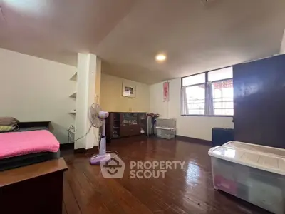 Spacious bedroom with wooden flooring and ample natural light, ideal for cozy living.