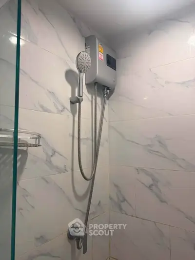 Modern bathroom with sleek showerhead and marble tiles, perfect for a luxurious home experience.