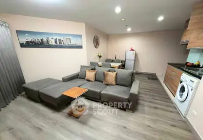 Modern living room with sleek furniture and open kitchen layout in stylish apartment.