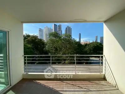 Spacious balcony with city skyline view, perfect for relaxation and enjoying urban living.