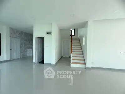 Spacious modern interior with sleek staircase and glossy tiled floors