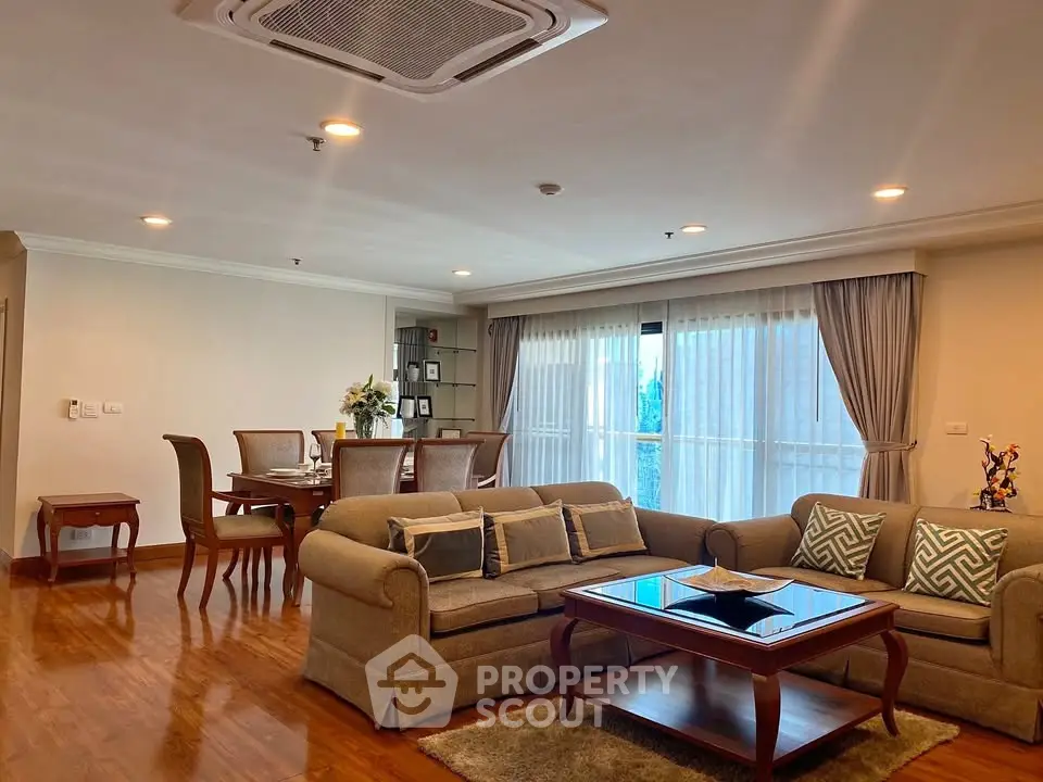 Spacious living room with elegant furniture and large windows in a modern apartment.
