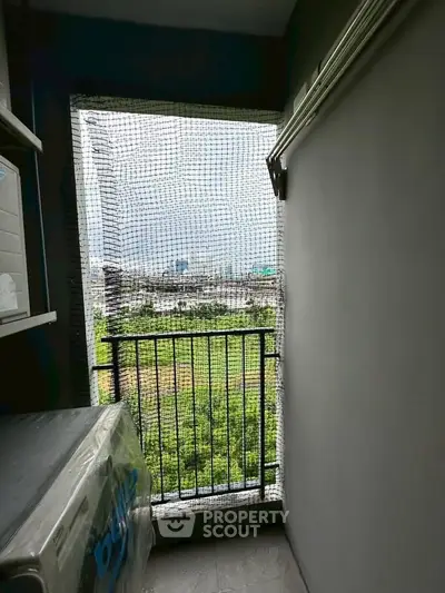 Compact balcony with safety netting and scenic city view, ideal for urban living.