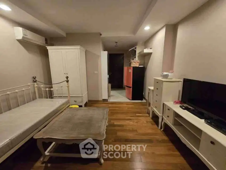 Cozy living room with wooden flooring, stylish furniture, and modern appliances.