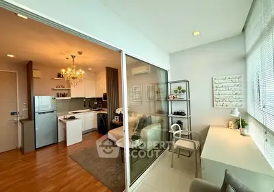 Modern open-plan living room with kitchen and study area, featuring elegant decor and natural light.