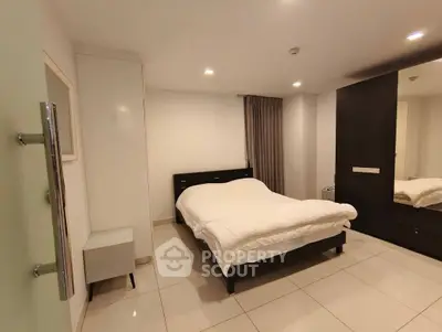 Spacious modern bedroom with sleek furniture and tiled flooring