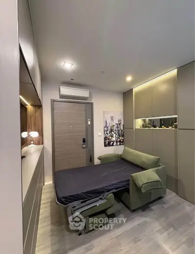 Modern studio apartment with convertible sofa bed and sleek cabinetry