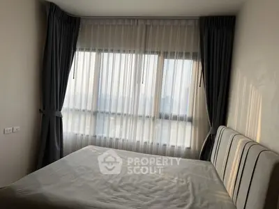 Cozy bedroom with large windows and elegant curtains, perfect for natural light lovers.