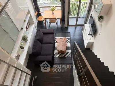 Modern loft-style living room with dark wood floors and stylish furniture.
