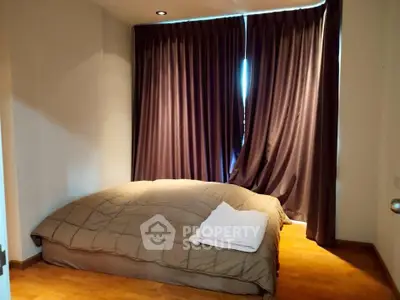 Cozy bedroom with warm lighting and elegant curtains, perfect for relaxation.