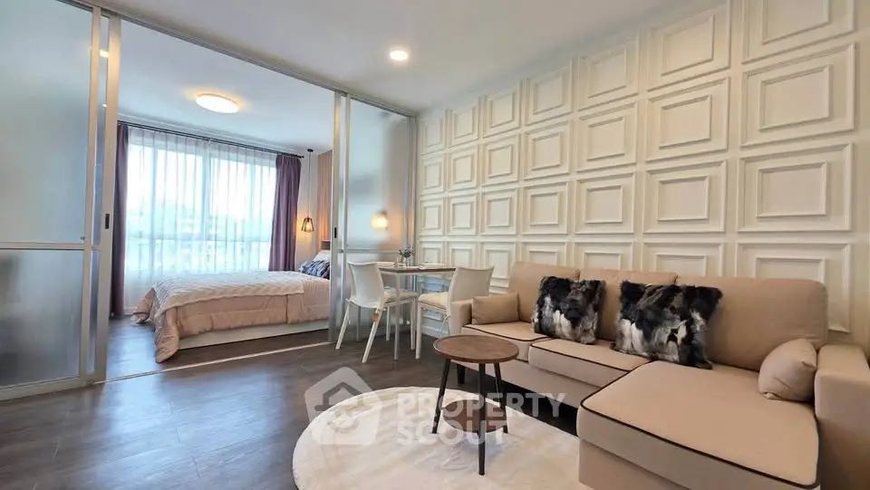 Modern open-plan living room with stylish decor and cozy bedroom view