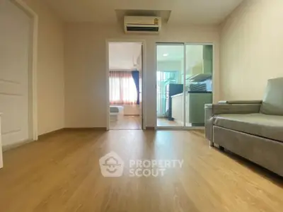 Spacious living room with modern air conditioning and view into kitchen and bedroom