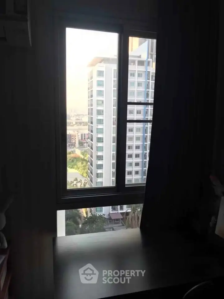High-rise apartment window view with cityscape and neighboring building.