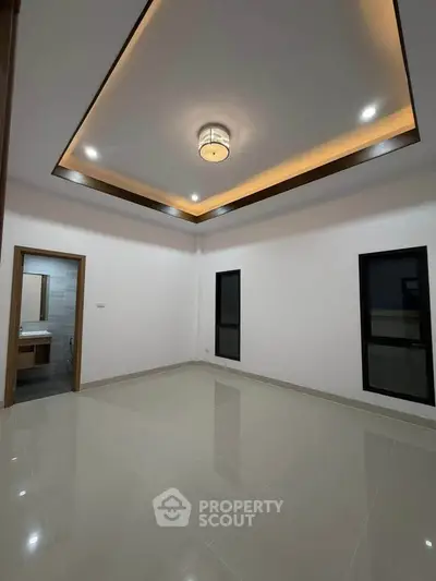 Spacious modern room with elegant ceiling lighting and glossy tiled floor