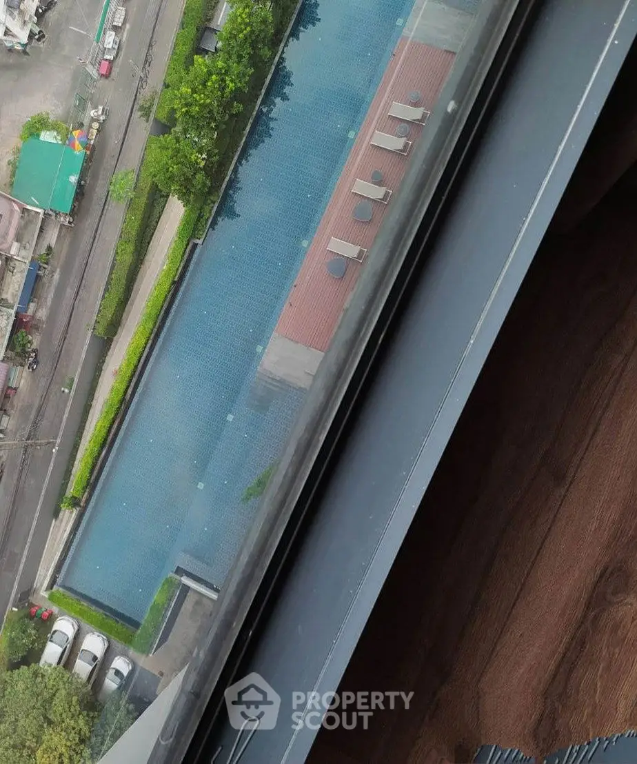 Stunning aerial view of a luxurious rooftop pool from a high-rise building window.