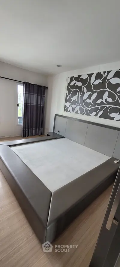 Spacious modern bedroom with stylish decor and large bed frame, perfect for comfort and relaxation.