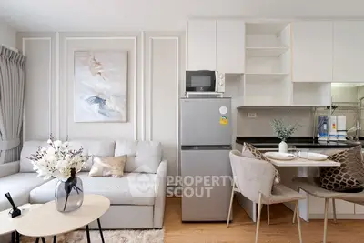 Modern living room with stylish decor and compact kitchen area in open layout apartment.