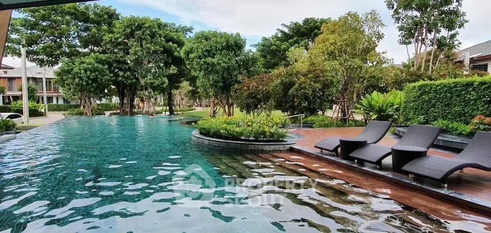 Luxurious outdoor pool area with lush greenery and stylish loungers, perfect for relaxation.