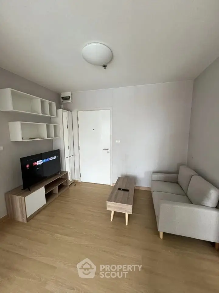 Modern living room with minimalist decor, featuring a sleek TV unit and comfortable sofa.