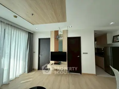 Modern living room with stylish decor and open kitchen layout, featuring natural light and contemporary design.
